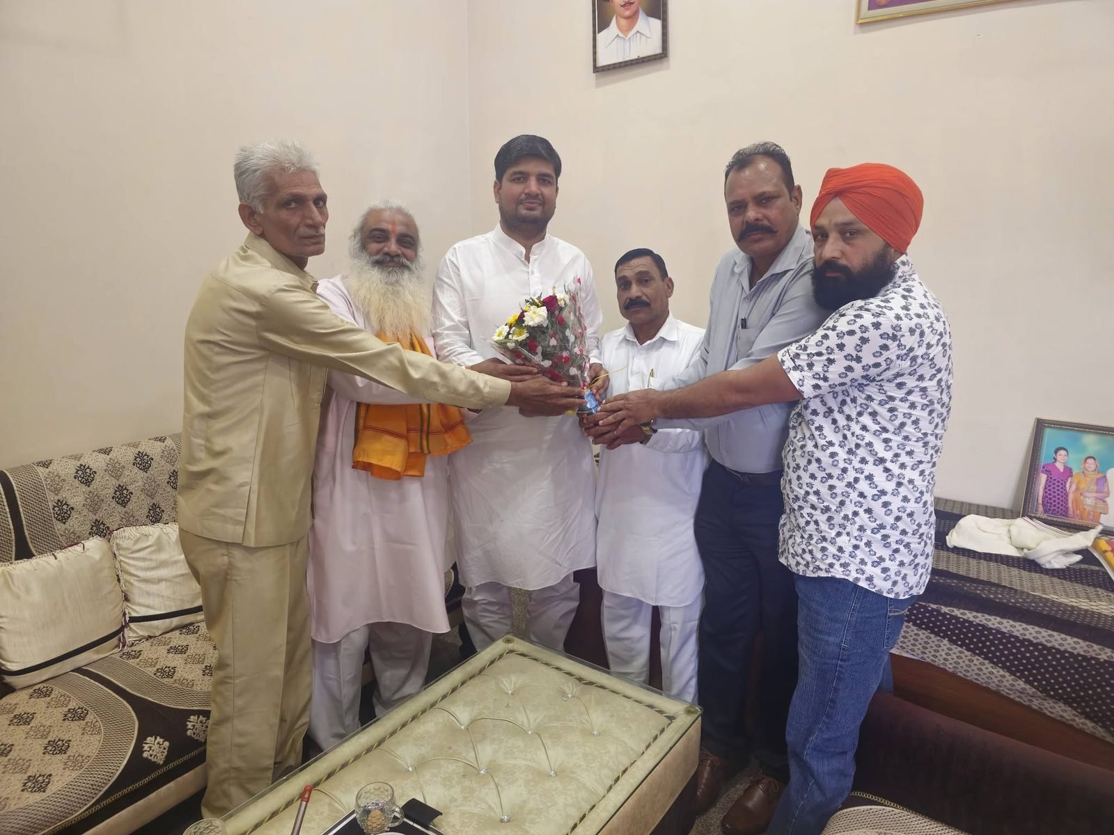 Sanstha members presenting a bouquet to a guest at a community meeting