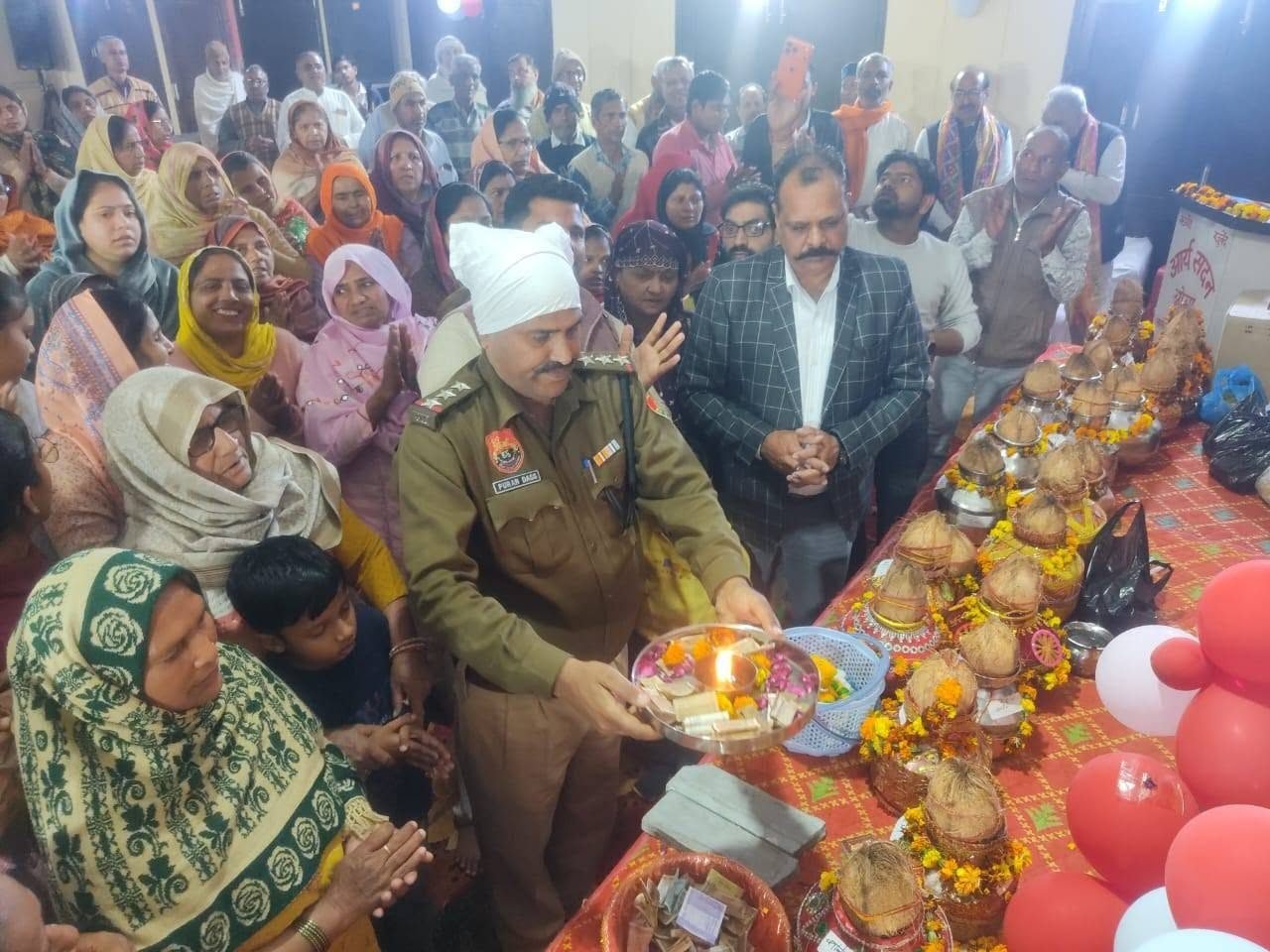 A police officer performing aarti at a Sanstha programme