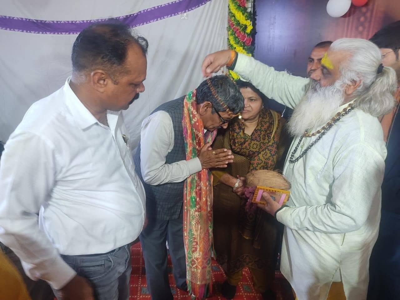 An elderly couple receiving a blessing at a Sanstha programme