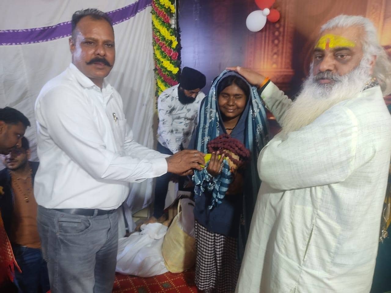 Winter woollens and a sack of provisions handed to a girl at a Sanstha programme
